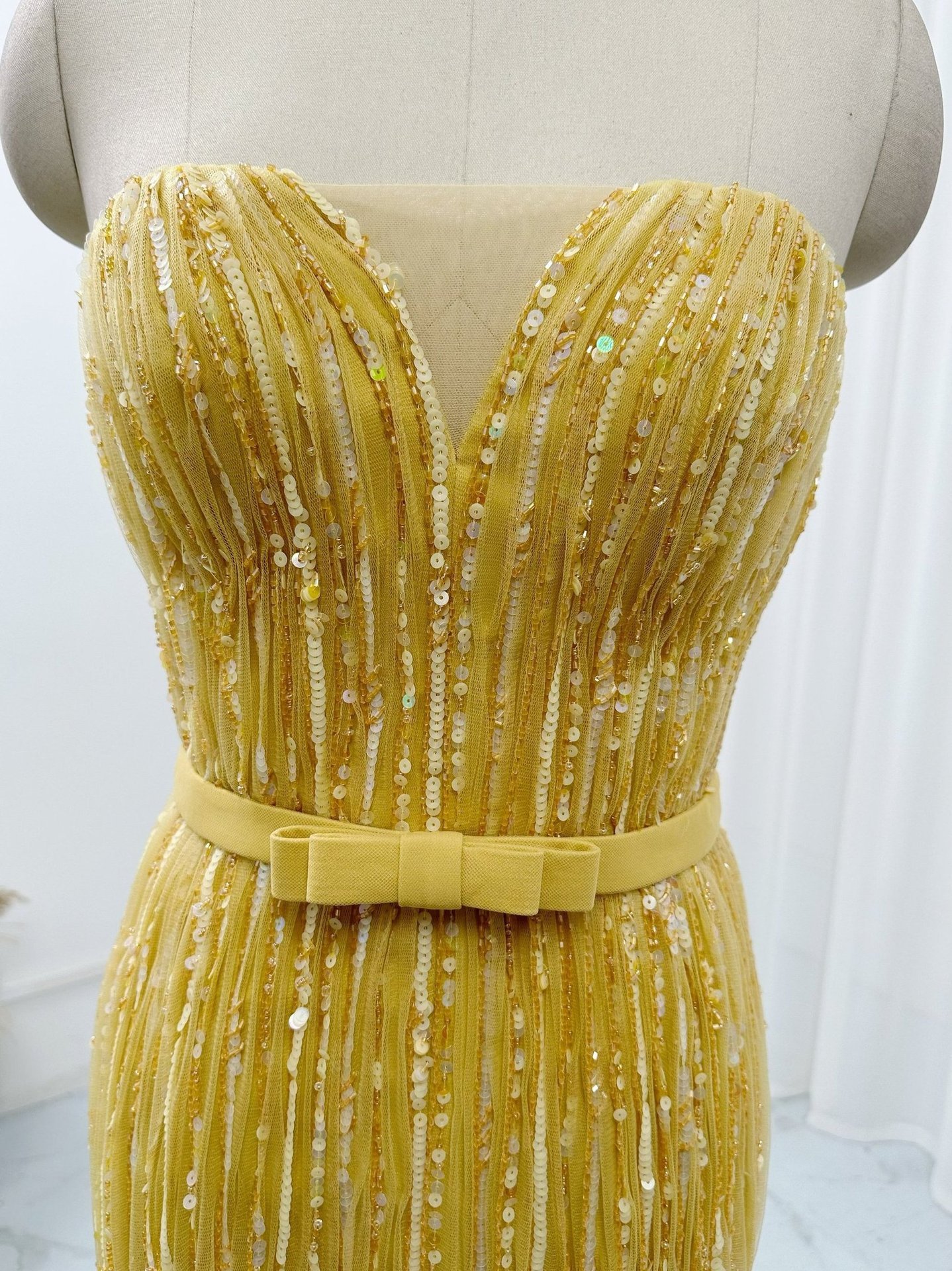 Sweetheart corset bodice detail on golden yellow sequin prom dress